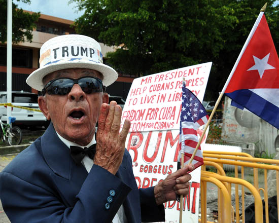 A man holds signs referencing US President Donald Trump’s policy on Cuba, in Miami, Florida, on Friday  (AFP photo)